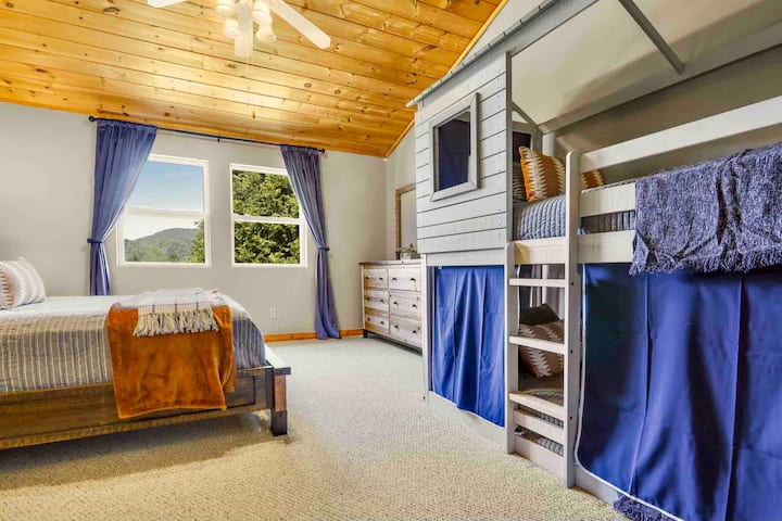 Chumba cha kulala cha ghorofani kilicho na kitanda cha malkia na vitanda viwili. Angalia mtazamo kutoka kwa madirisha juu hapa! 