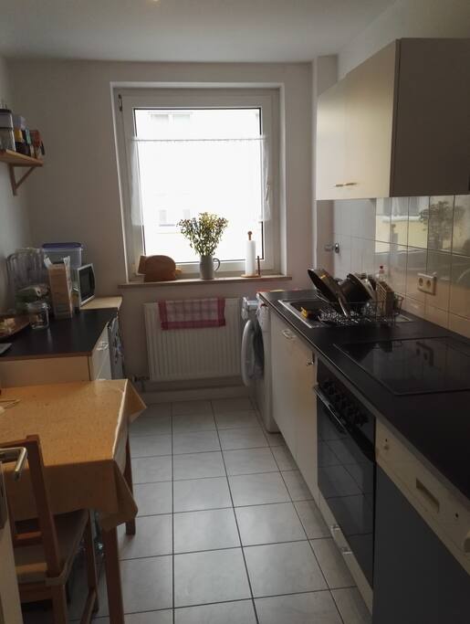 Küche mit Waschmaschine, Mikrowelle und Kaffeemaschine