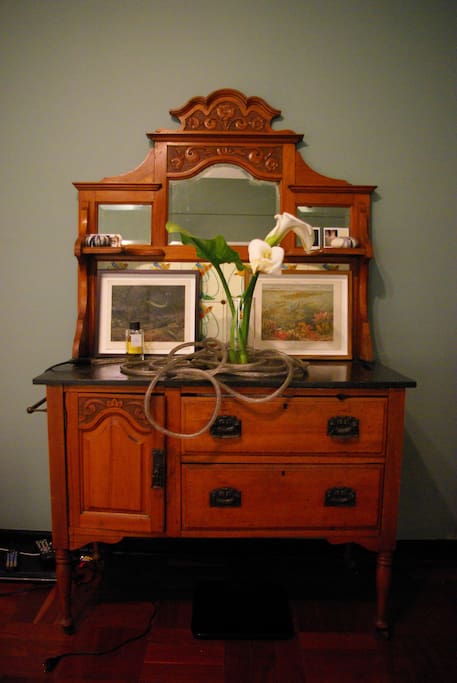 Antique, rose-wood dressing table, flanked by two velvet upholstered wing-back chairs in the main bedroom