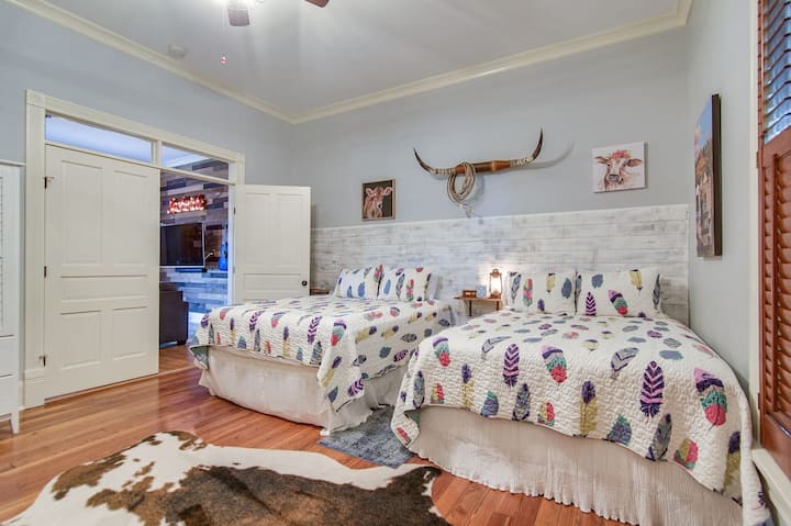 Dormitorio #3-2 Camas tamaño queen con sofá envolvente en forma de L de 7' x 7'