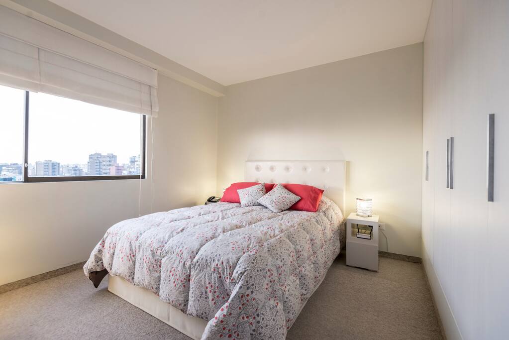 Dormitorio con cama queen