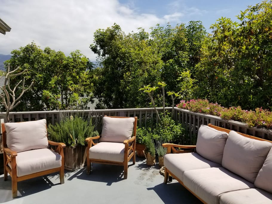 Outdoor living space with mountain and city views. Furniture and a gas bbq make this an ideal summer hangout.