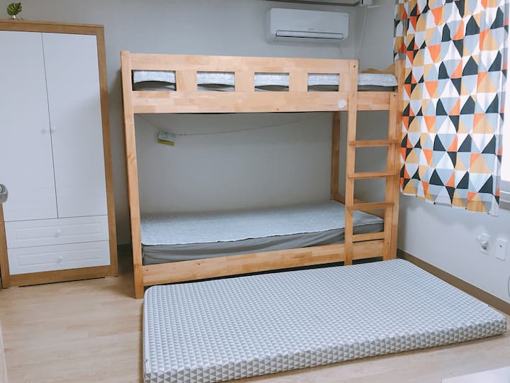 地板上有一张双层床和一张单人垫子。