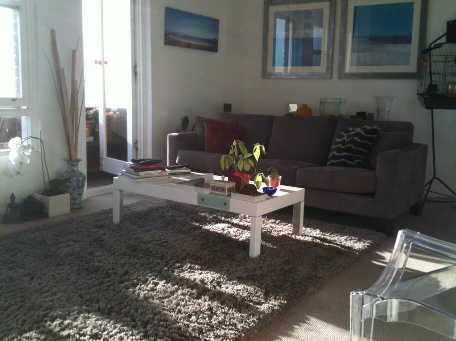 Sunny living room with balcony access.