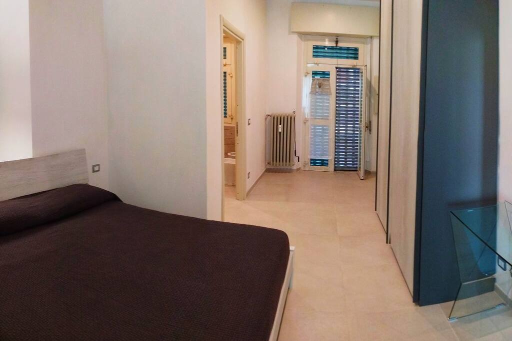 Zona notte, letto matrimoniale anallergico, grande armadio, accesso al piccolo patio esterno