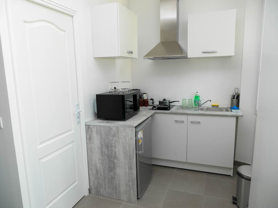 Cuisine équipée avec four micro ondes, hotte, frigo, cafetière, bouilloire, plaques de cuisson...