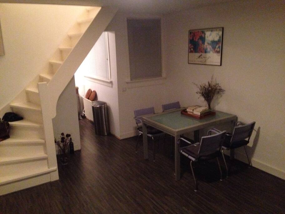 Living room with dining table and stairs to main bedroom