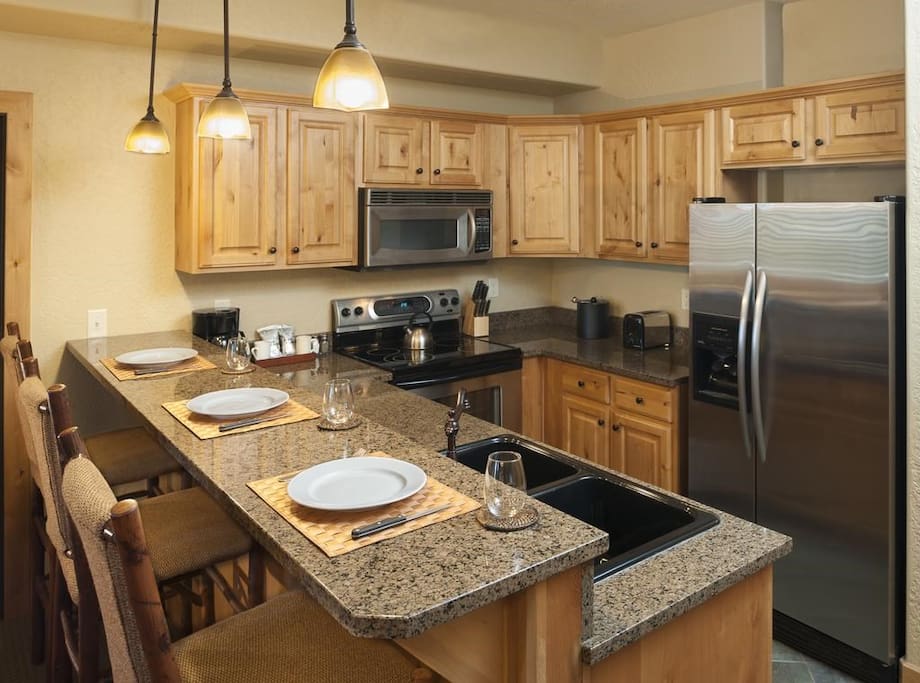 The fully-equipped kitchen features granite countertops and a breakfast bar