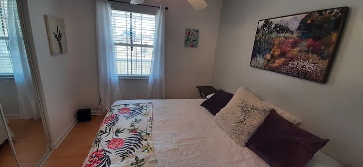 Cama King en una habitación con flores silvestres