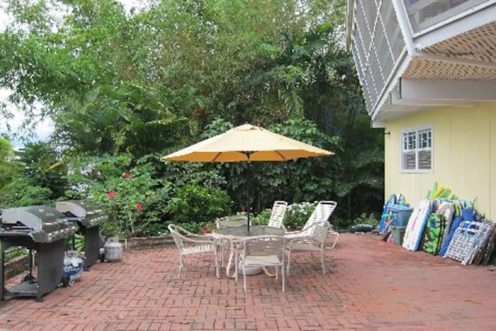The home is a full two stories from both sides and this rear. Note the boogie boards, beach chairs & swim noodles on the wall. This patio area may be shared by others in the house
