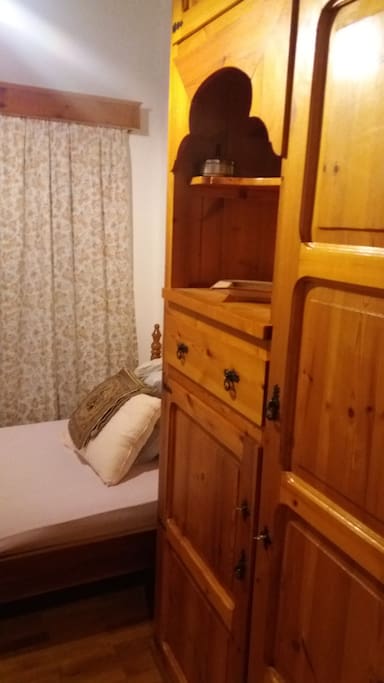 Bedroom with single bed, wardrobe and drawers. Everything is traditionally handmade by the owner of the house who is a carpenter.