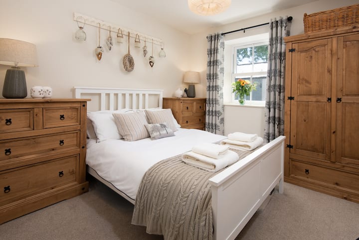 The pretty bedroom, adjacent to the shower room, has a comfortable double bed with crisp white cotton bedding and plenty of drawer and hanging space for clothes - so there’s no need to pack light!