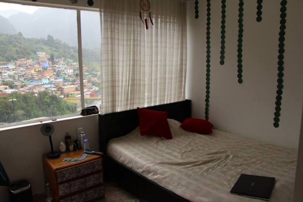 Room. Big window facing Monserrate mountain, double bed, blankets and sheets, nightstand, lamp, big built-in wardrobre, small working table