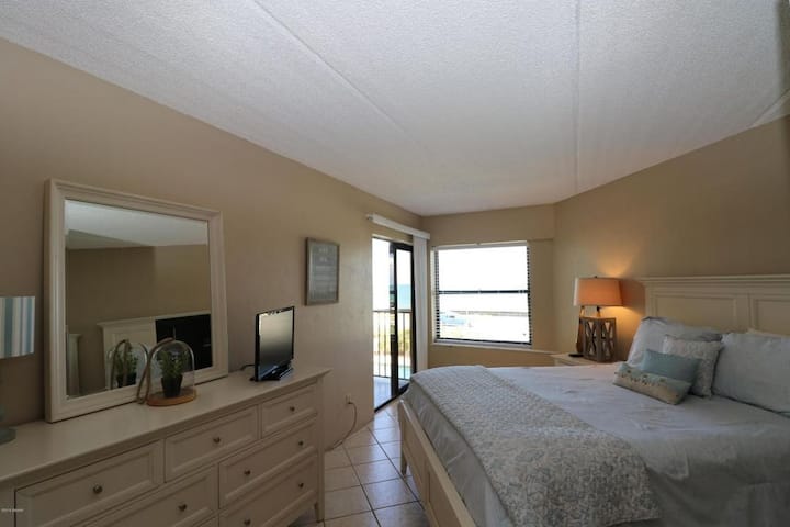 חדרי שינה שניים על החוף עם מיטת קווין סייז מתהדרת בזריחות ים יפהפיות וגישה למרפסת.