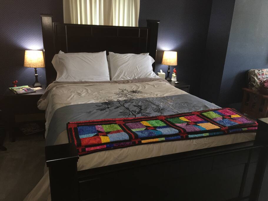 Comfy queen size bed with lots of pillows.