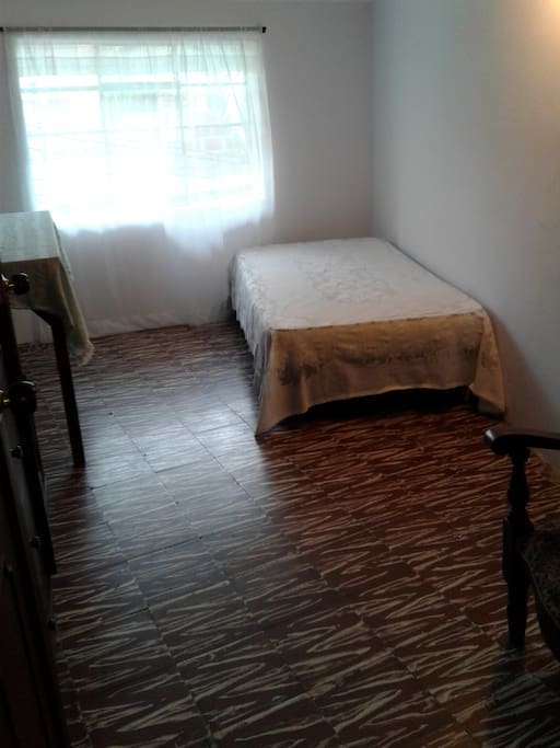 habitación amplia, iluminada con su cama
