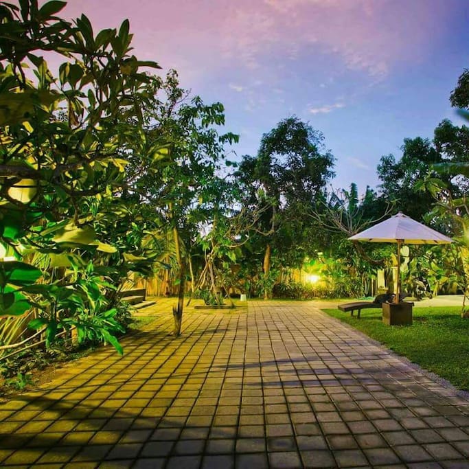 Guest house entrance with parking facilities and lush greenery