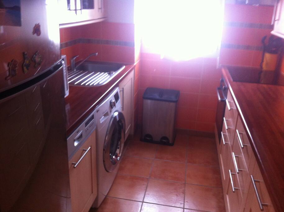 Cuisine tout équipée fonctionnelle : plaque de cuisson induction, four multi-fonctions, lave-linge 8 kg silencieux, lave-vaisselle, micro-ondes, cafétière Nespresso, robot Magimix, réfrigérateur/congélateur, plan de travail spacieux
