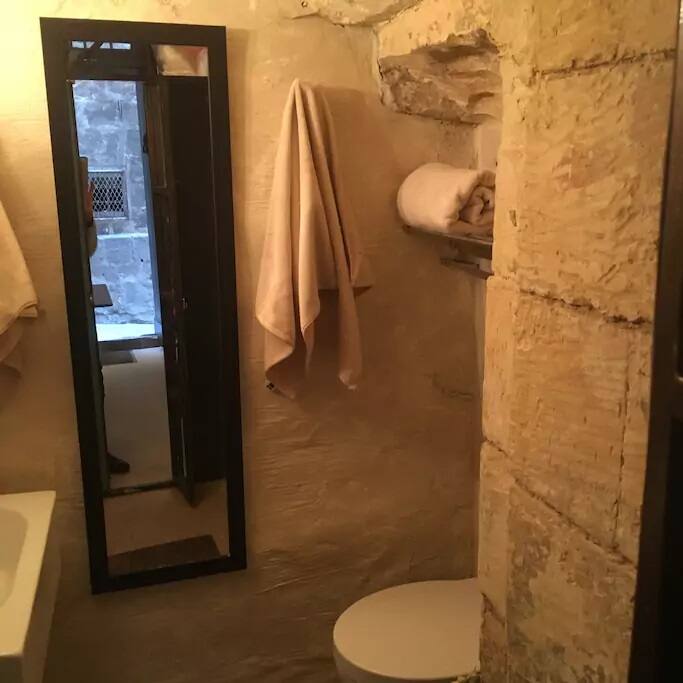 This is the miracle I had to create: a bathroom in a hole! It's a walk-in shower as soon as you get in, with a floor drain. Not a palace-like size, but does its job quite well.
A mop is lodged behind the basin to help with excess water.