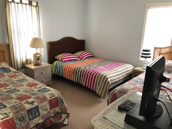 Dormitorio 2. El tamaño completo está en la esquina con 2 individuales en los lados. Incluye armario, cómodas y TV.