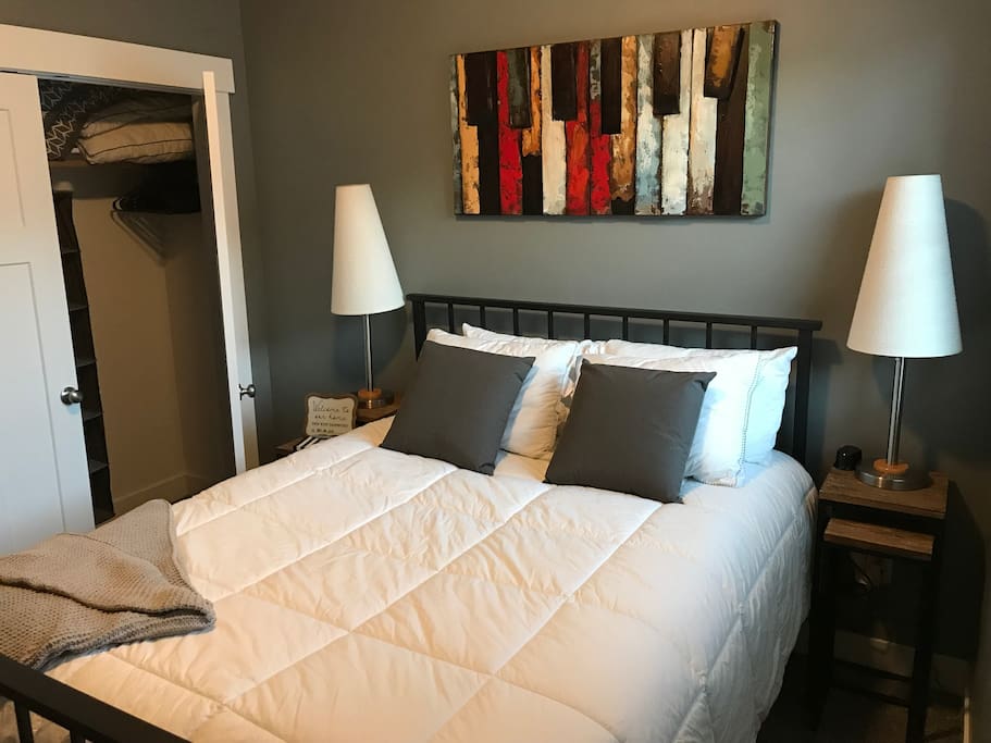 Guest bedroom #1 with lamps for additional lighting, closet space, and a ceiling fan to help regulate temperature.