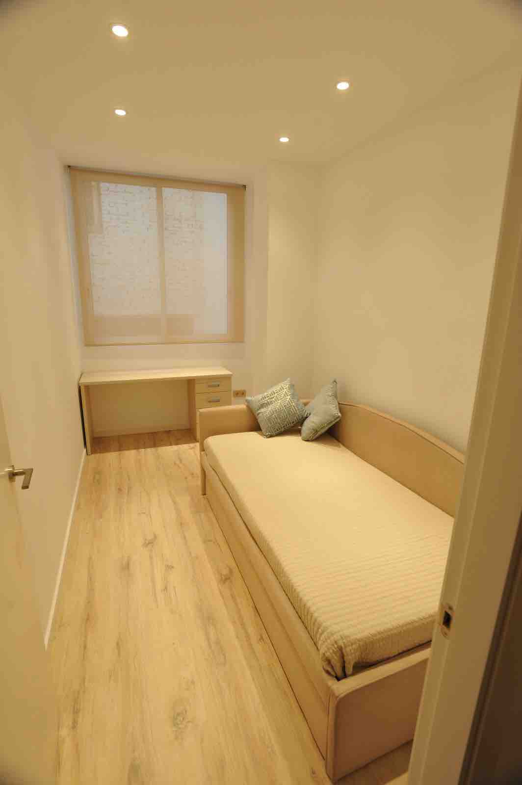 kamer met uitschuifbed met twee 90 bedden en bureau tafel. 