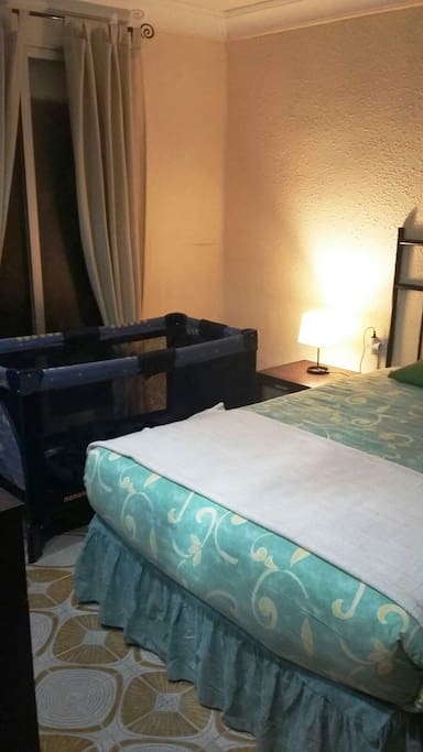 Hay una cuna plegada en el canapé de la cama de matrimonio
