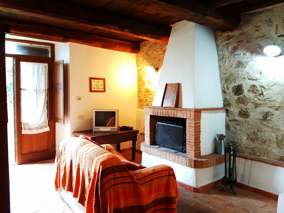 Cucina/sala completa di divano, camino e tv
