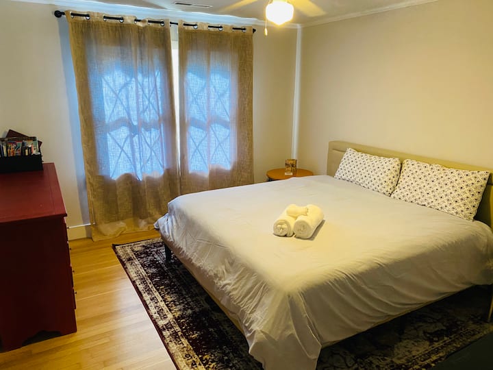 Recámara en la planta alta con cama tamaño king, Smart TV de 50 pulgadas, pisos de madera y mobiliario cómodo en una casa vacacional de 5 recámaras en Mount Pleasant, Carolina del Sur.