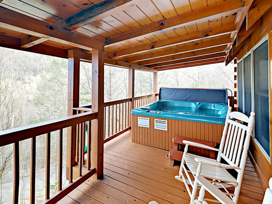 Secluded, 2-story deck with rocking chair and huge hot tub.