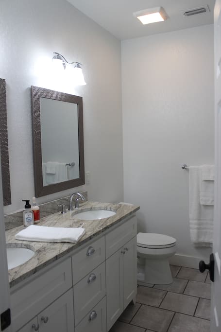 Across the hall is a shared bathroom with double sink vanity and full bath.