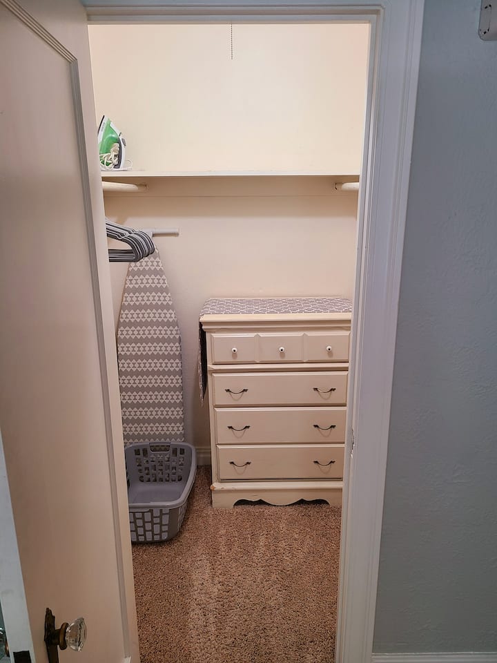 خزانة كبيرة مع قضبان على كلا الجانبين لتعليق الملابس والشماعات وخزانة الملابس والمكواة وطاولة الكي 