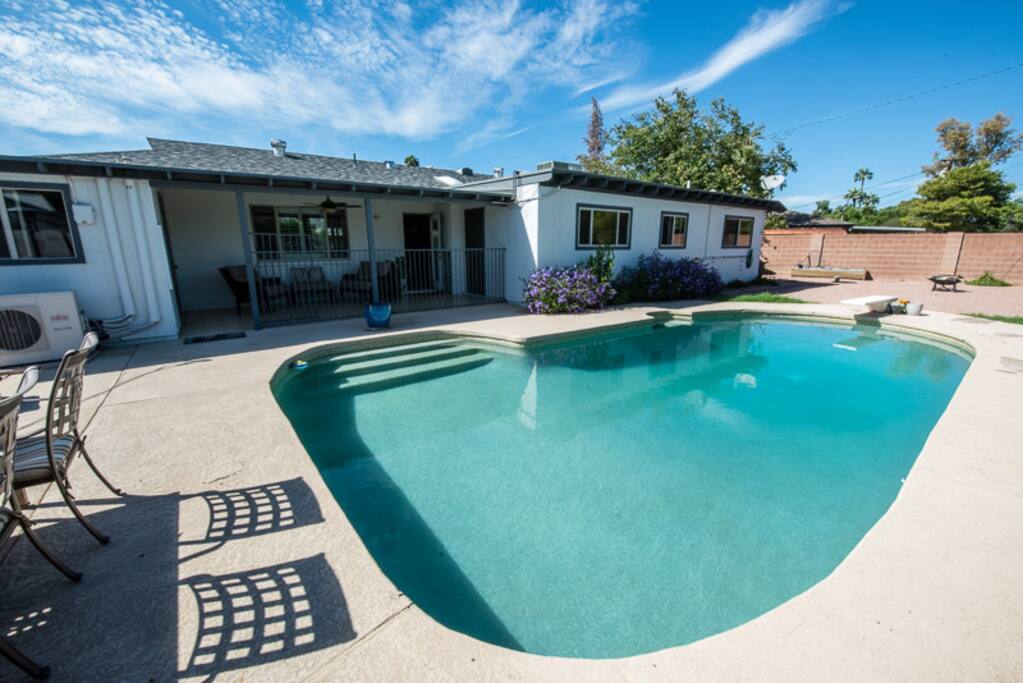 Big backyard with bbq, lounge chairs, and table.
