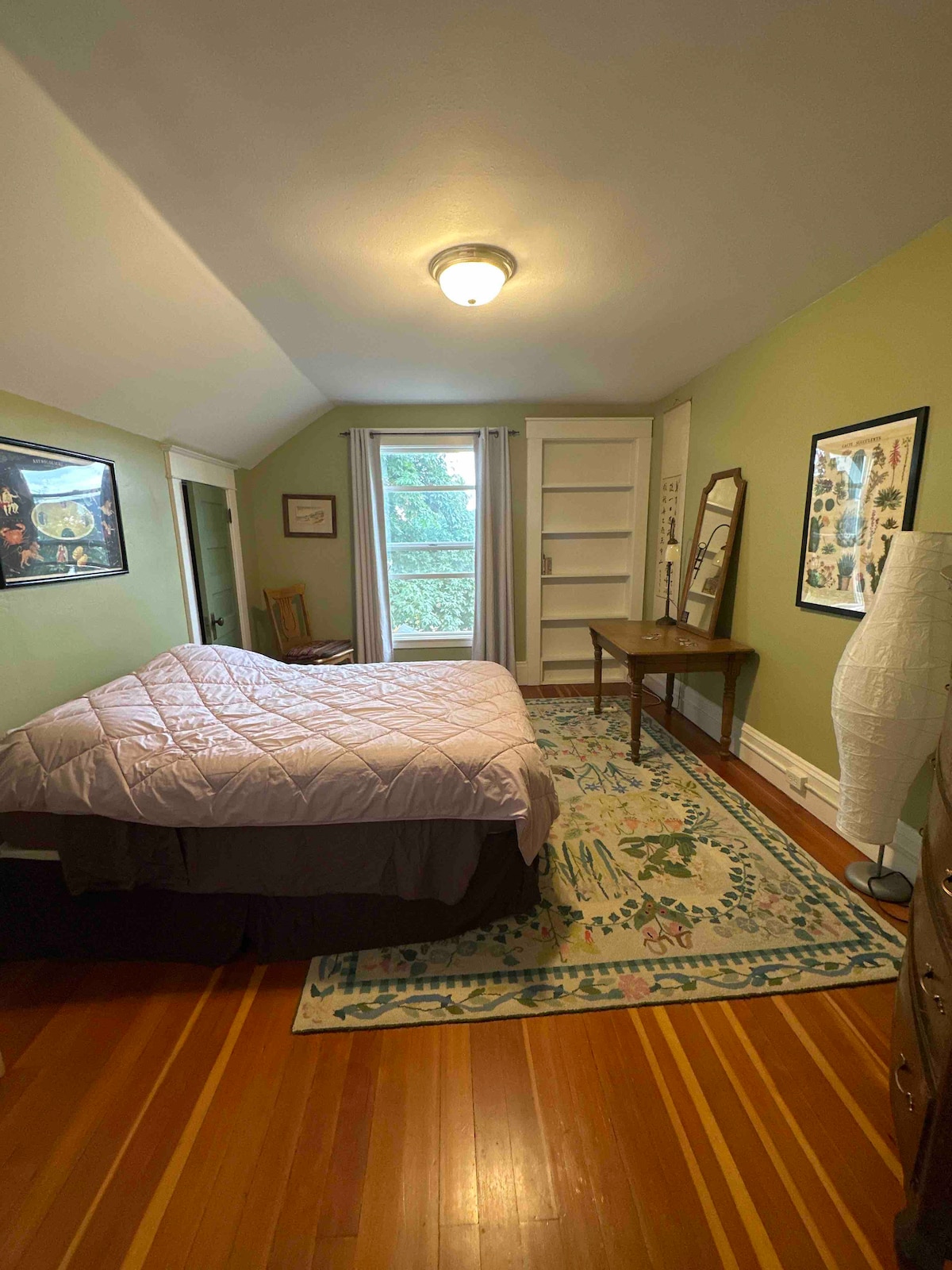 تحتوي غرفة النوم هذه في الطابق العلوي على سرير كامل ومكتب وخزانة كبيرة 