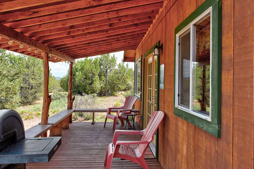 FRONT PATIO: Adirondack chairs and plenty of bench seating on covered deck.