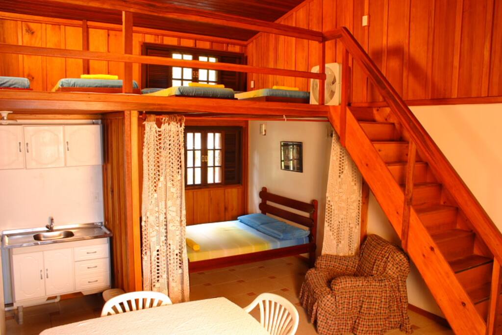 Vista da entrada (cozinha, cama de casal e escada para o mezanino)