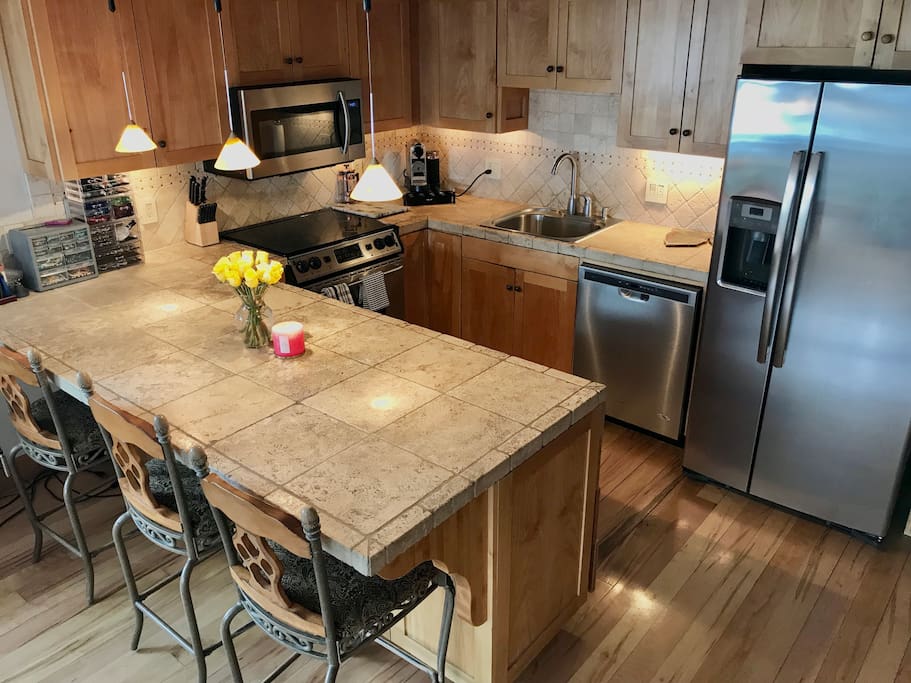 Kitchen with stainless steel appliances and Nespresso + milk frother.