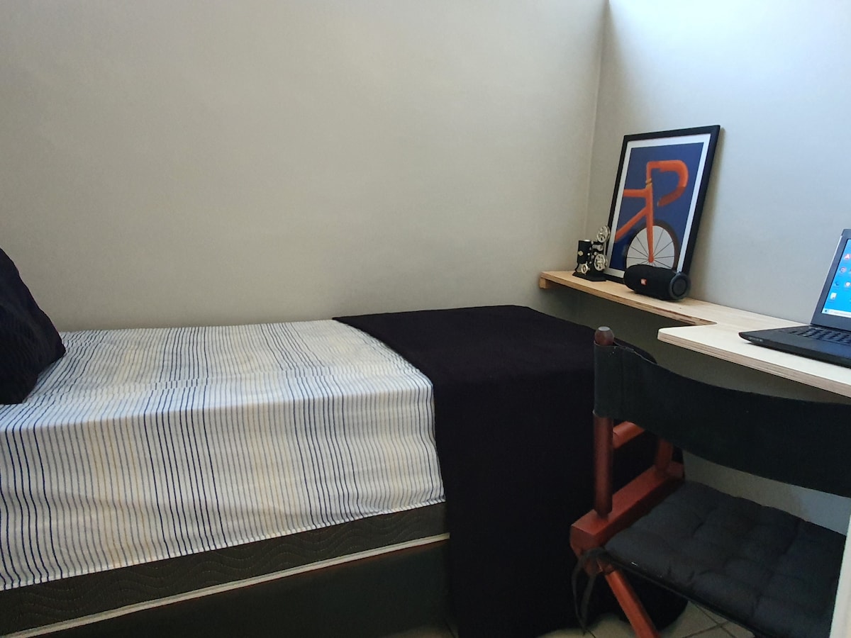 Chumba kimoja chenye kiyoyozi na dawati kwa ajili ya kazi.