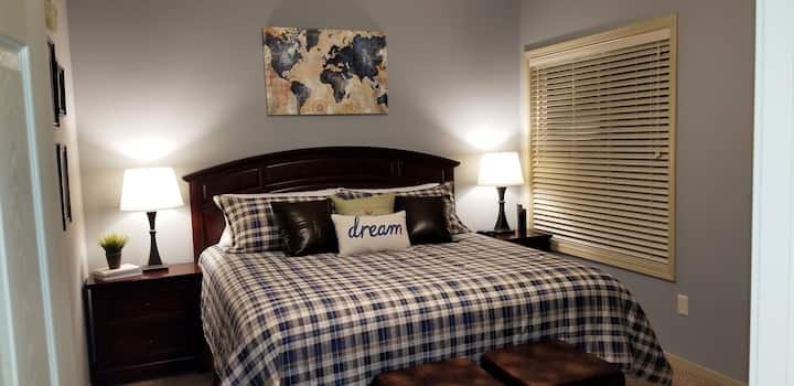 Dormitorio de invitados con cama tamaño king y baño completo adyacente y accesible a través de la puerta de bolsillo