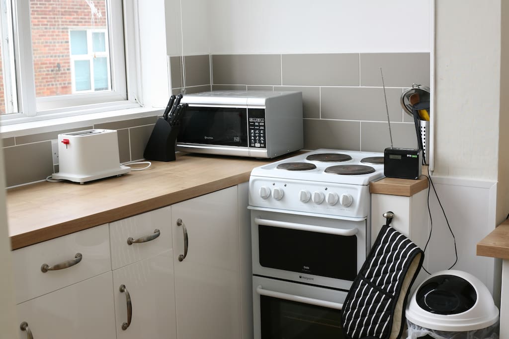 The kitchen has a fridge, coffeemaker, microwave, toaster and electric cooker with a oven and grill.