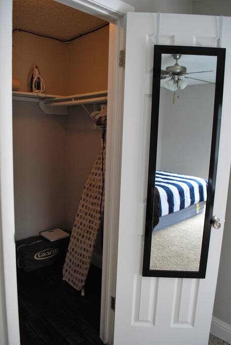 Closet in BR 1 has iron, ironing board, and Graco pac n play