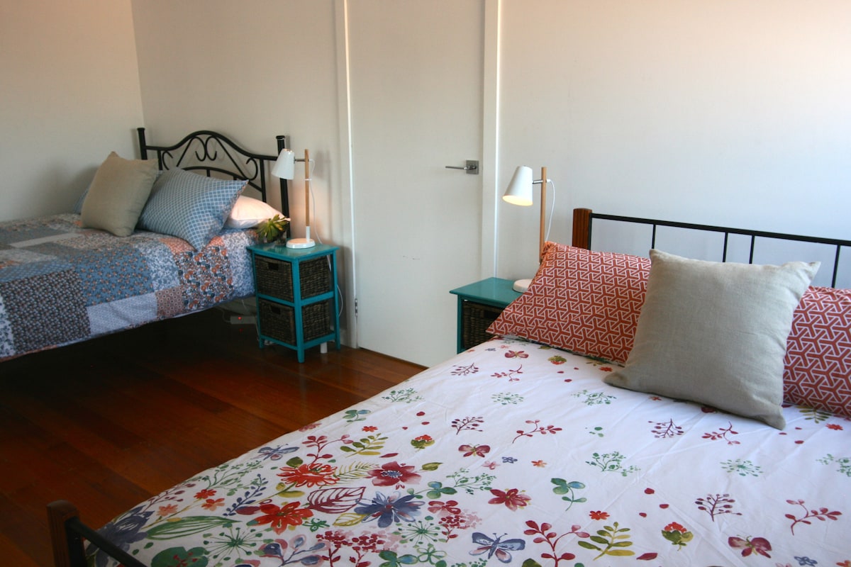 Prostrana spavaća soba na katu s bračnim krevetom i bračnim krevetom izvan sobe za zabavu