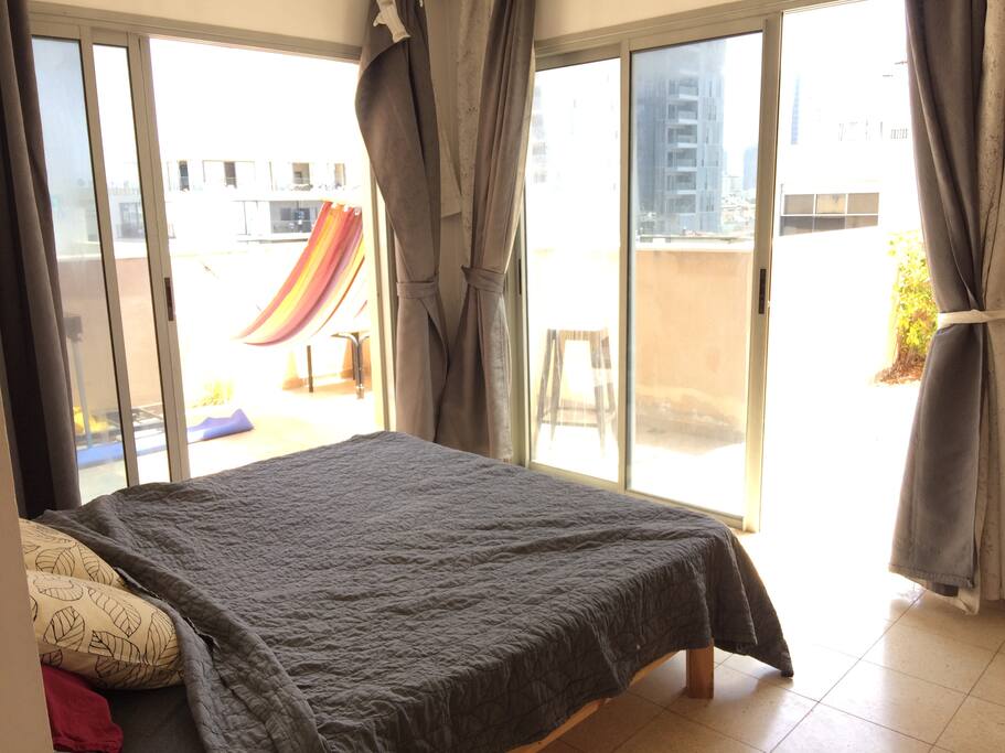 Second floor bedroom with large windows facing a huge porch.