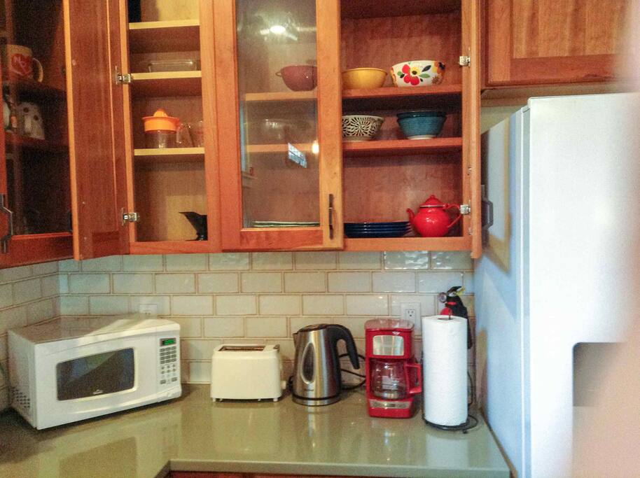 Microwave, toaster, electric kettle, coffee machine, place settings for four.