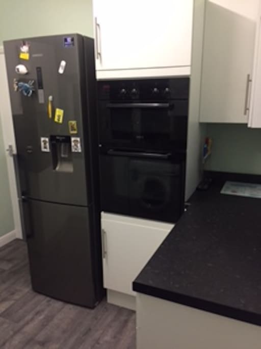 Kitchen with double over (with grill) and fridge/freezer