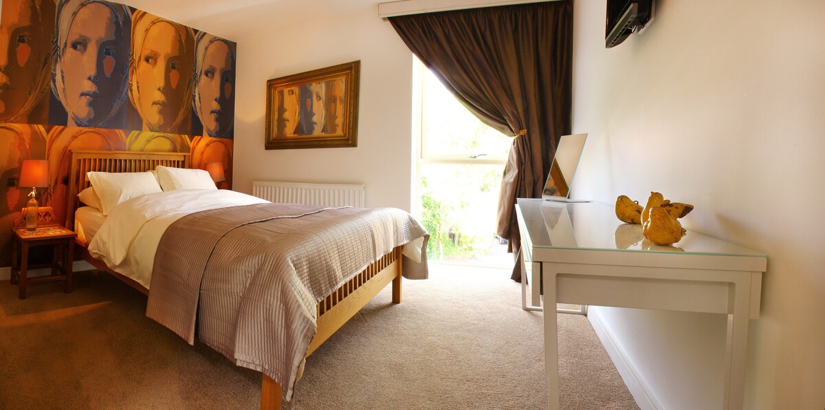 חדר שינה ראשי יוקרתי בהשראת אמנות פופ עם מיטת קינג - סייז ומזרן מסתמך. בחדר השינה הראשי יש גם טלוויזיה עם נגן די .וי .די משולב.