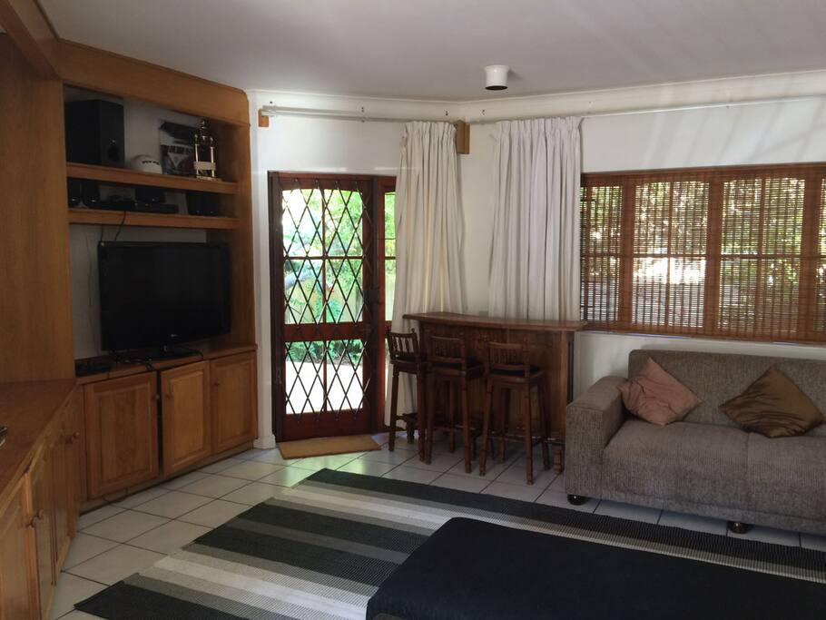 Lounge with TV leading onto a private patio area