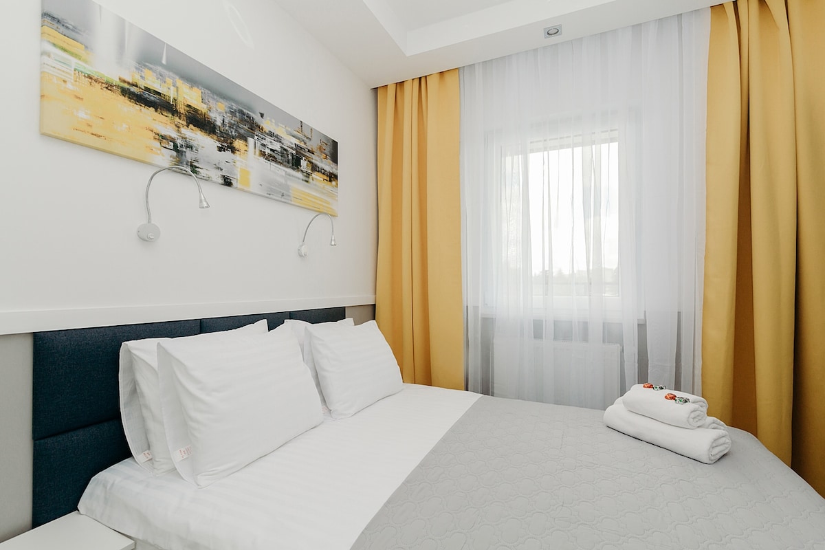 spálňa s veľkým šatníkom, pracovným priestorom a inteligentným televízorom.