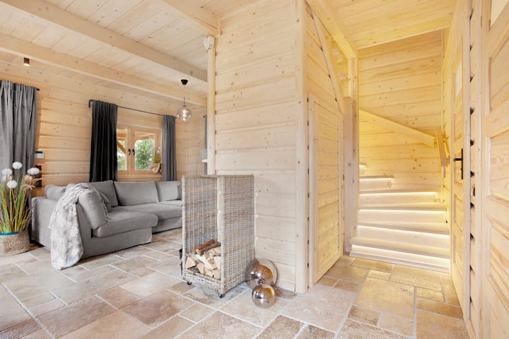 คอทเทจไม้มีสไตล์ในซาซิโน - ห้องนั่งเล่น… พื้นหญ้าเชื่อมต่อหลากหลายสีตั้งแต่สีน้ำตาลไปจนถึงดอกกุหลาบ
