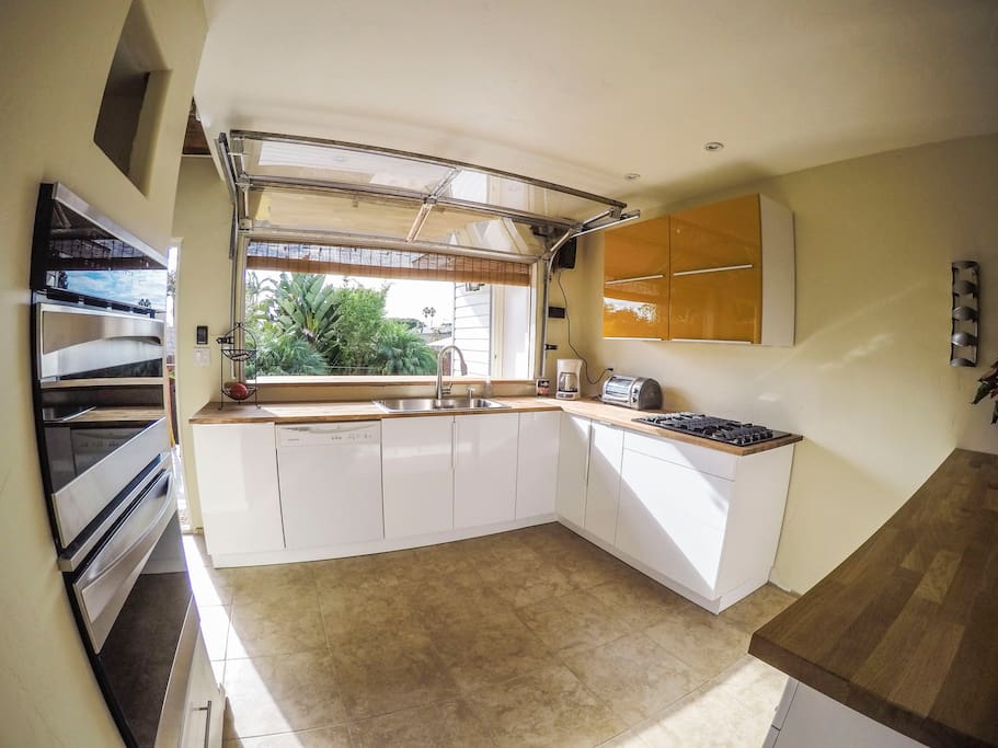 Custom roll-up kitchen window opens the space up for an indoor/outdoor gathering